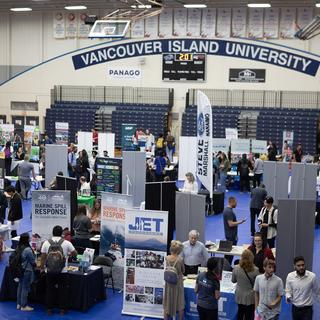 Aerial view of VIU gym with lots of booths and people milling about