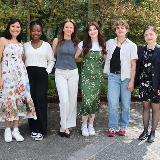 Six Vancouver Island University students standing together in front of a bush