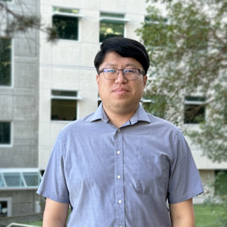 Cliff Feng standing outside of a building at VIU and looking at the camera.
