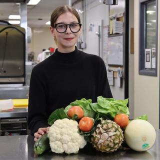Isabelle with fruits and veggies piled in front of her