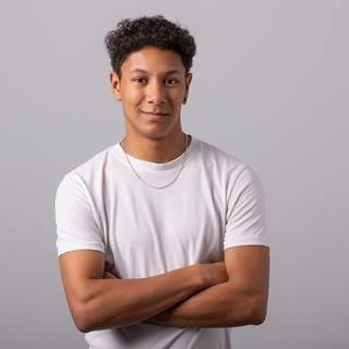 Michael Joseph standing with his arms crossed and smiling at the camera.