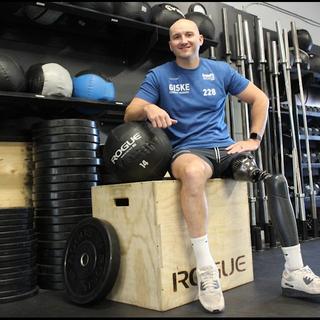 a male sits on a workout box
