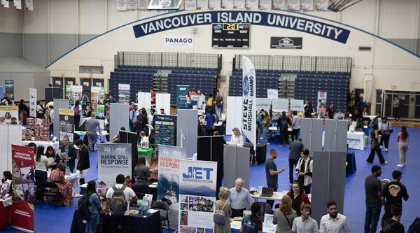 Aerial view of VIU gym with lots of booths and people milling about