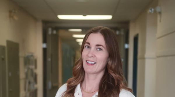 Shauna stands in the hallway