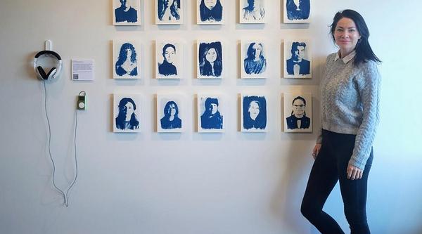 Tarah stands in front of her exhibit