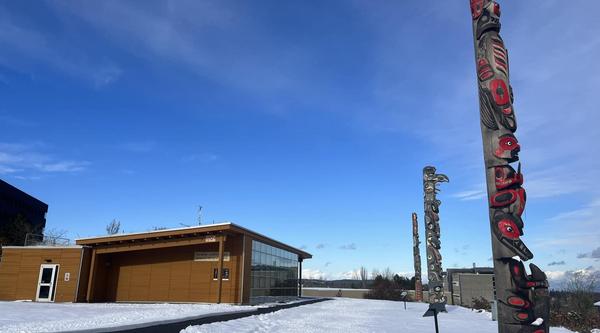 VIU's three totems outside Shq'apthut on the Nanaimo campus