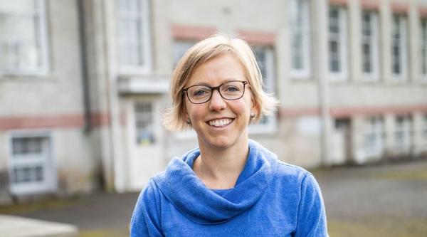 Alison Garnett sitting on table and smiling at camera