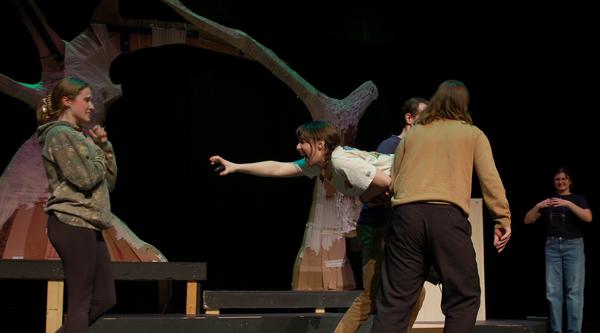 Hermia (Kaylin Zach) reaches her arms out to scratch Helena’s (Aimee Sweetapple) eyes out while being carried away by two other actors