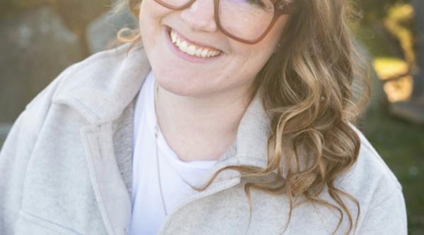 Ashley Kuramoto smiles with a natural and/or garden background