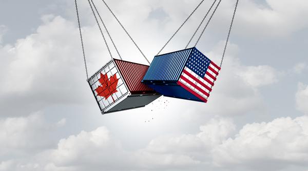 Two freight containers swinging into each other, one has the Canada flag, the other has the United States flag