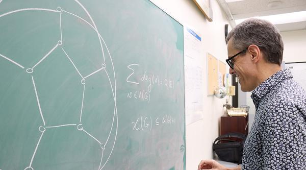 Cobus Swarts writes on a chalkboard.