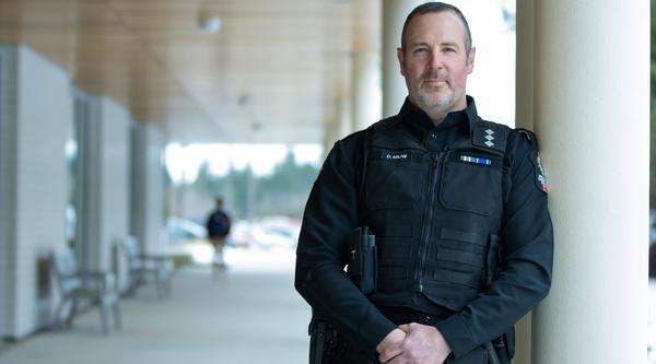 Drew Milne portrait next to VIU's Centre for Health and Science