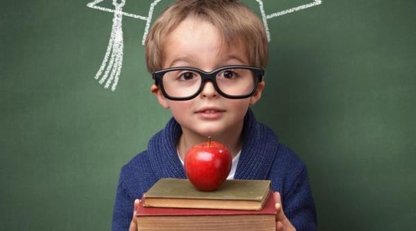 Image of kid holding books and an apple