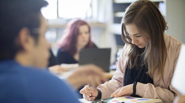 female student writing in notebook
