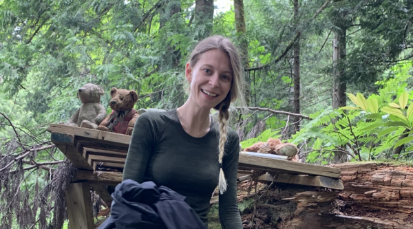 Isabelle Desrosiers in a green forest and smiling at the camera.