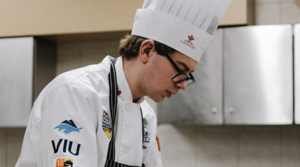 Simon Martin preaparing food in a professional kitchen.