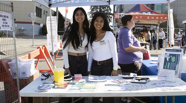Two students stand at a booth