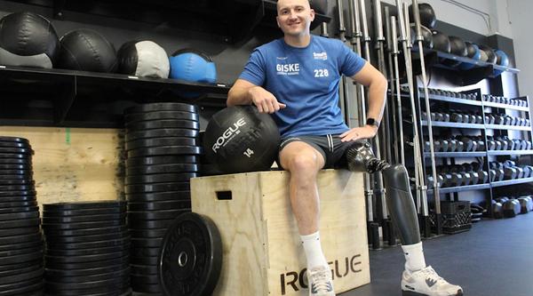 a male sits on a workout box
