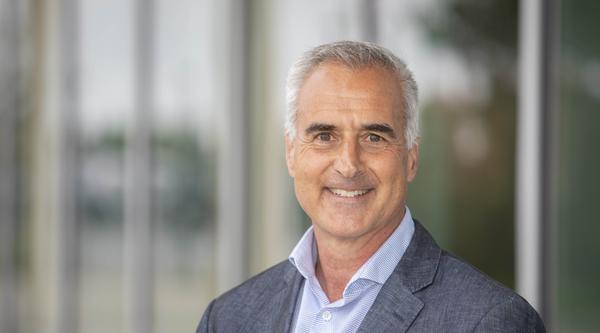 Head shot of Mike Quinn standing in front of the Centre for Health and Science at VIU's Nanaimo campus