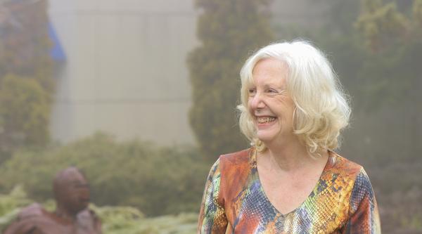 Pam Vickars stands in a garden area.
