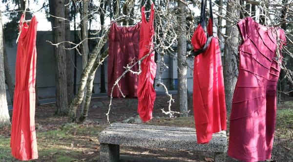Red Dresses hang on a tree branches
