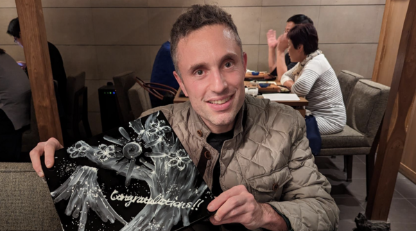 Avi Stenberg holding an award and smiling at the camera