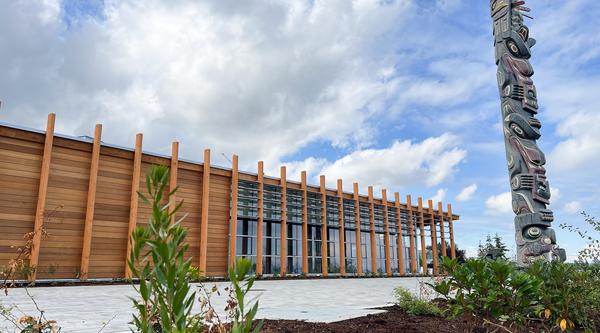 Photo of exterior of building with totem in foreground