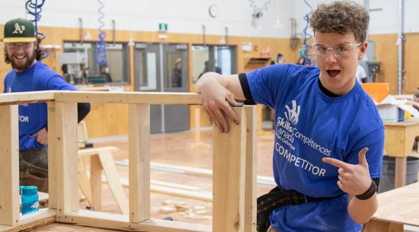 Two carpentry students work on a project