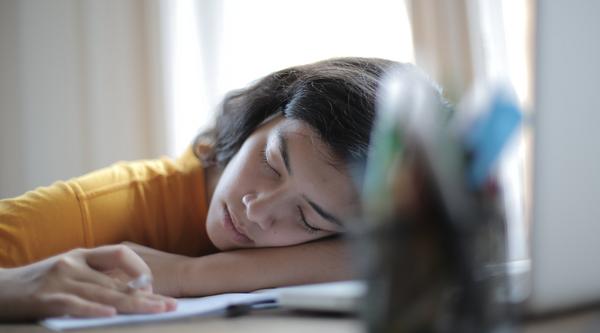 Student sleeping on her books