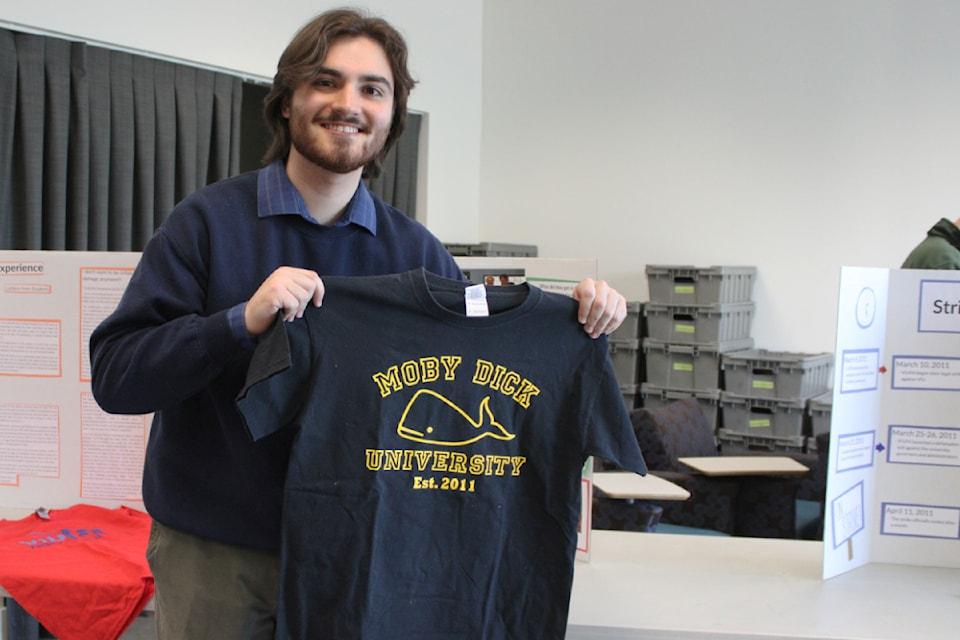 A student holds up a sweater that reads Moby Dick University