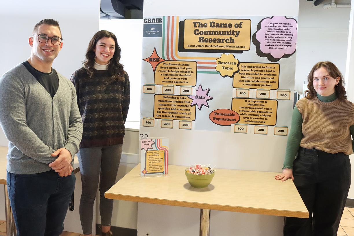 three people stand in front of a poster