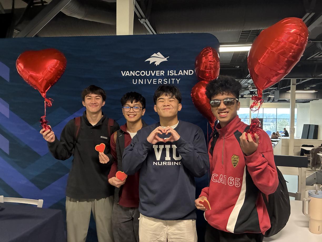 Group of male students in front of a VIU banner