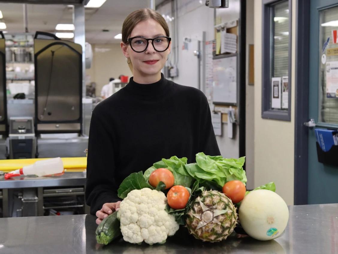 Isabelle with fruits and veggies piled in front of her