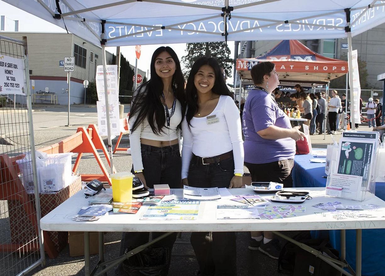 Two students stand at a booth
