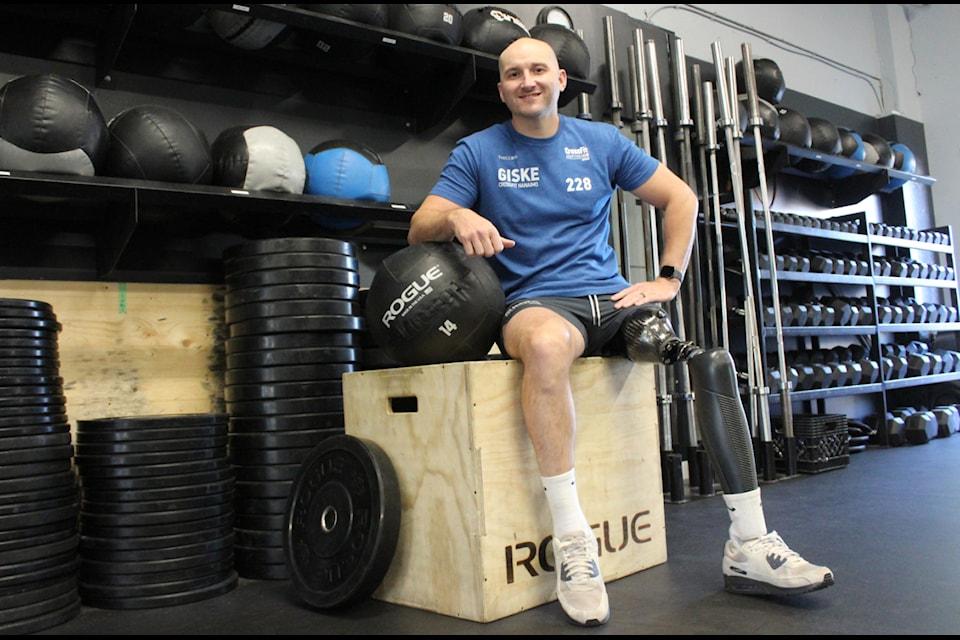 a male sits on a workout box