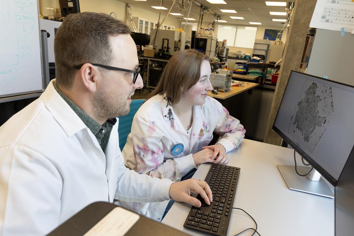 Kyle and Emily examine an image of a tumour on a computer screen