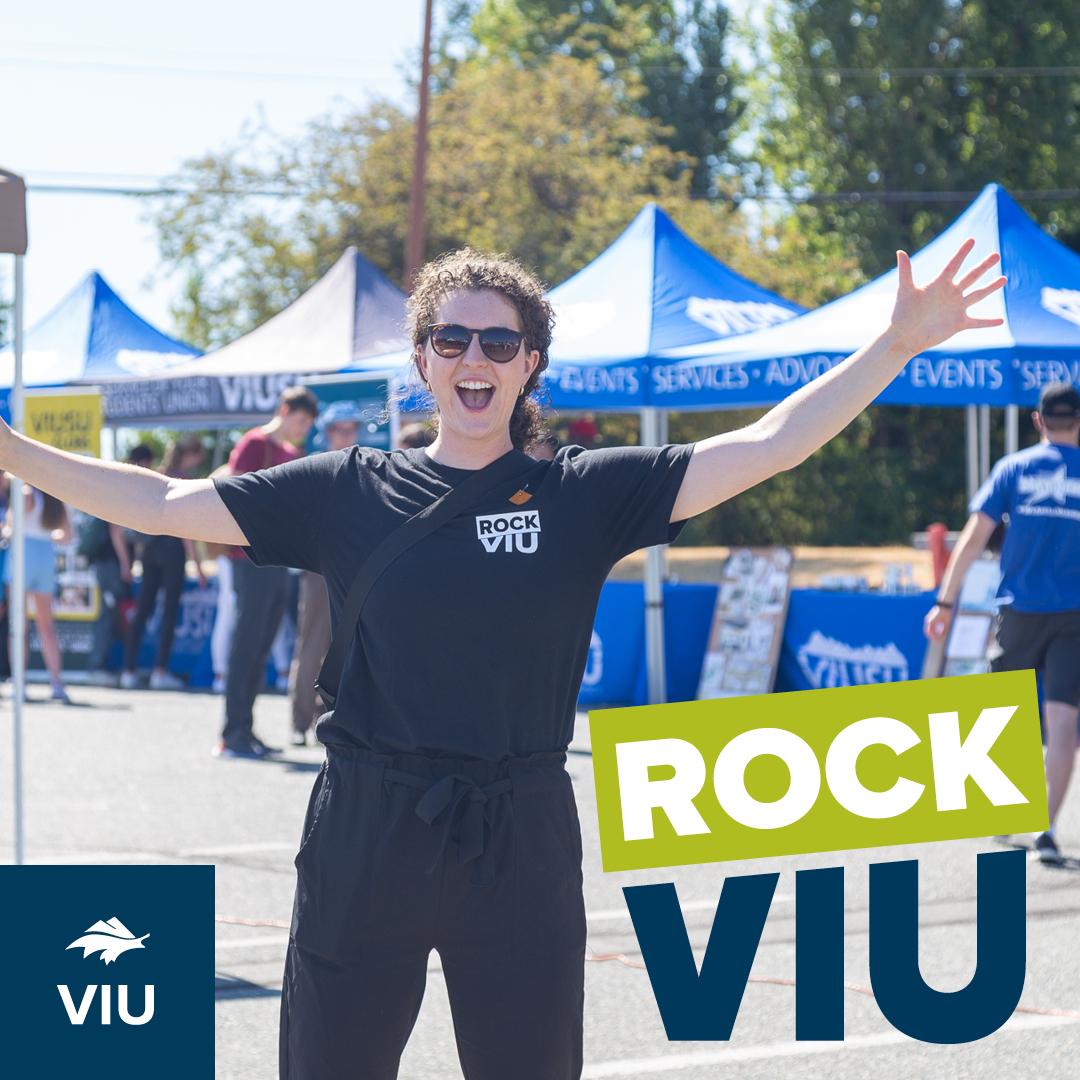 Girl with arms spread wide, tents behind her