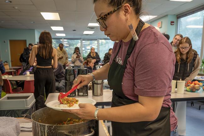 Leah serves food onto a plate