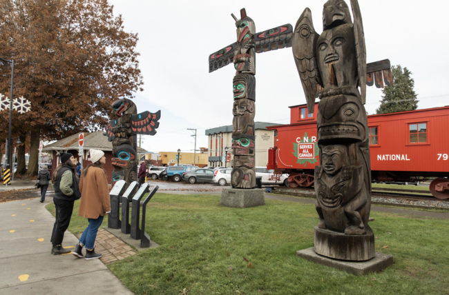 Two people looking at totem poles