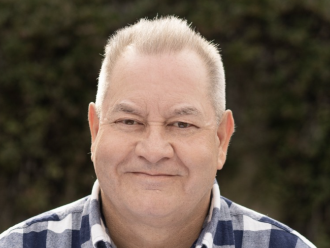 John outside and smiling at the camera.