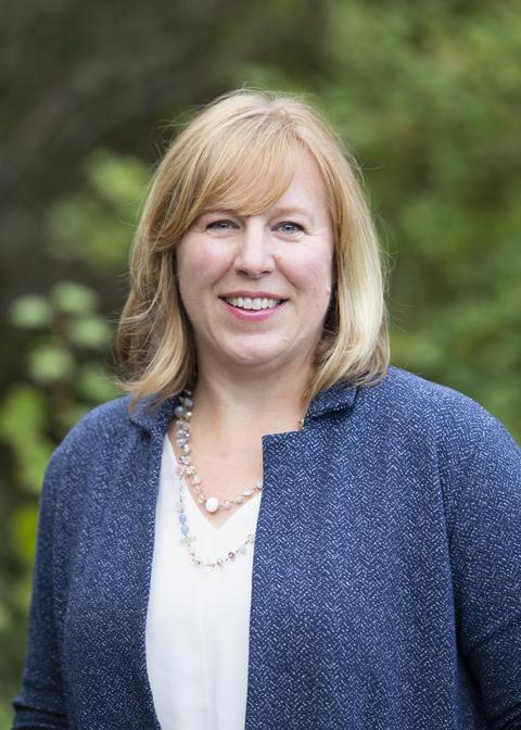 Carolyn Russell with a greenery background