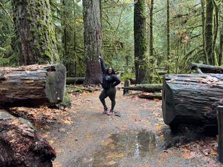 Black woman in between two huge logs