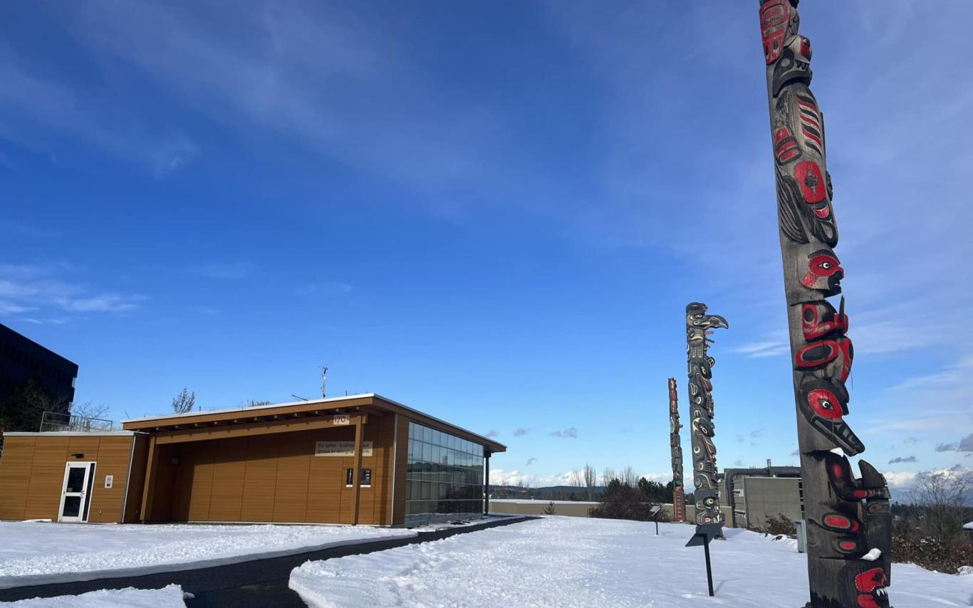 VIU's three totems outside Shq'apthut on the Nanaimo campus
