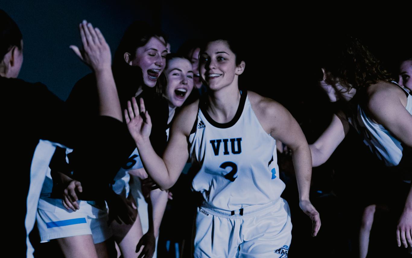 Amber runs by other basketball players giving high fives