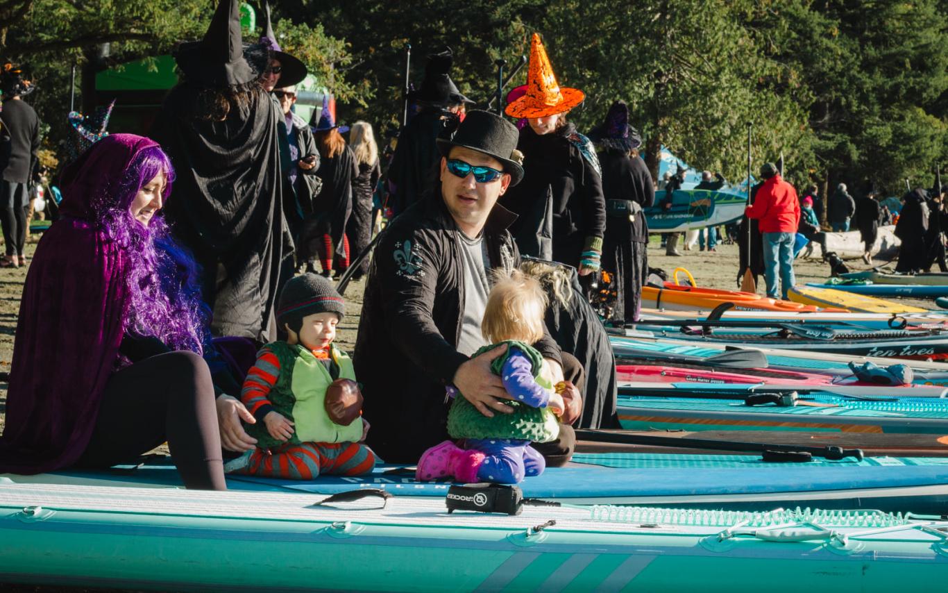 People dressed in costumes sitting on paddleboards at Westwood Lake