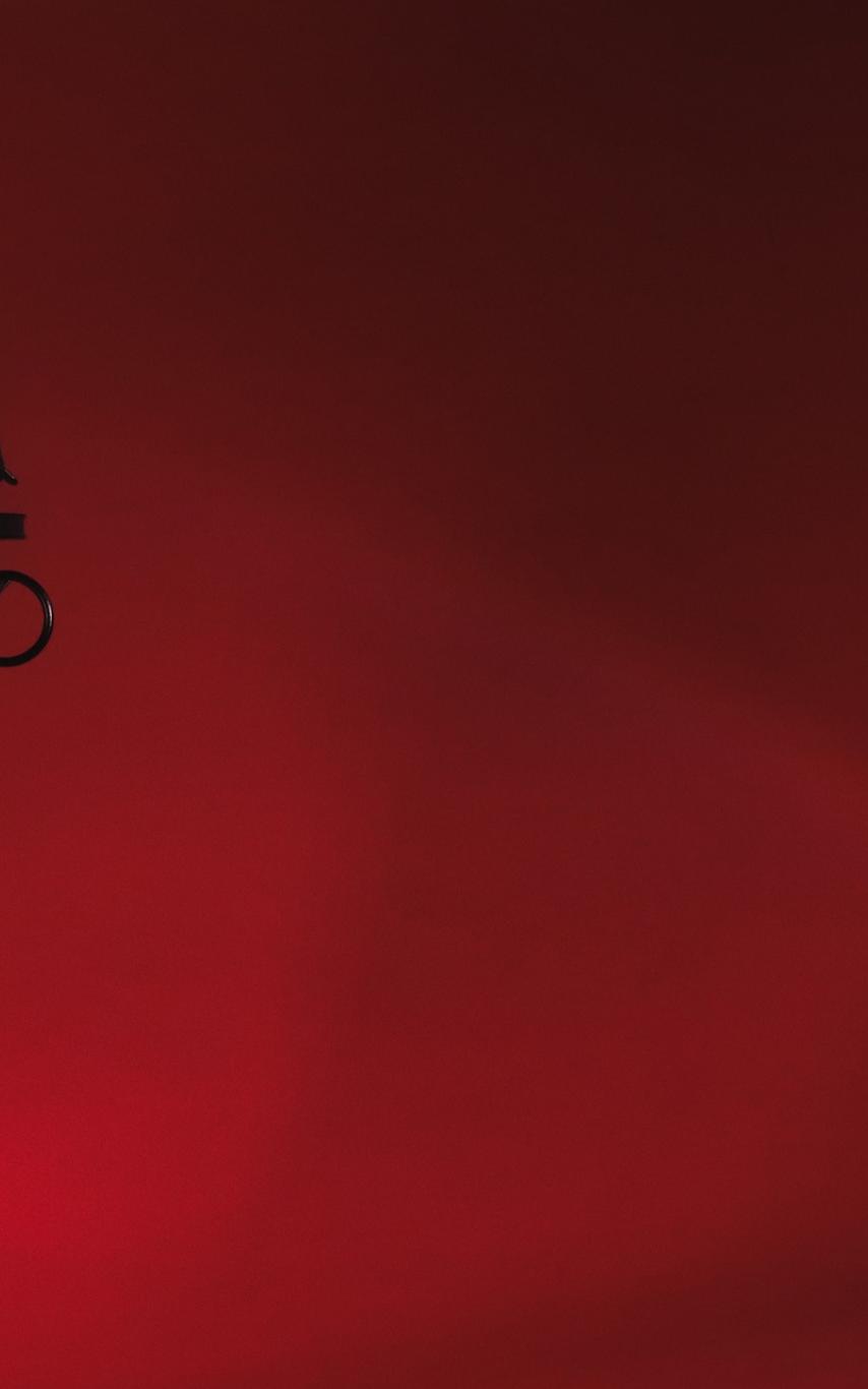 A podcast microphone in front of a red background.